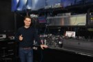 David Drahi standing in front of an optical bench giving a thumbs-up